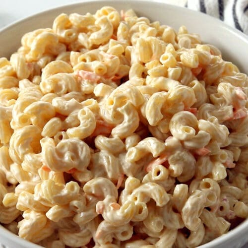 Creamy Hawaiian macaroni salad in a white bowl with macaroni, carrots, and mayo dressing.